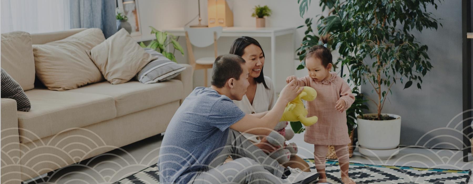 a couple and a child playing with a toy in front of a couch