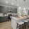 Modern kitchen with stainless steel appliances, white cabinets, and a breakfast bar.