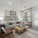 Bright living room with large windows, modern furniture, and a cozy area rug.