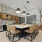 Modern clubroom kitchen with stainless steel appliances, a large island with bar stools, and sleek cabinetry