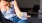 woman holds a drink while sitting