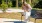 lady sits on a bench and holds her dog