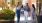 friends walk down a sidewalk with shops