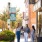 friends walk down a sidewalk with shops